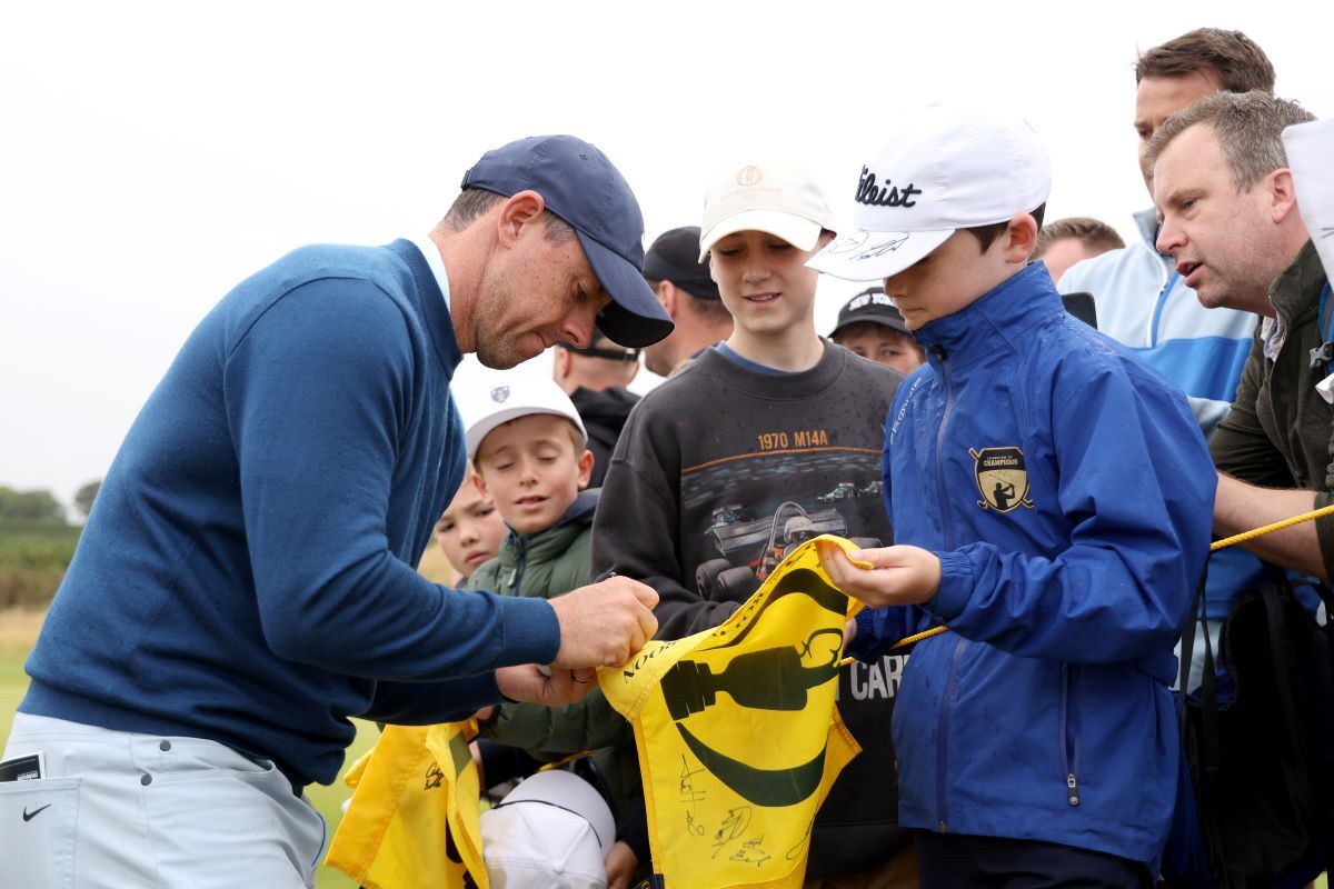 Rory Mcilroy signs autographs for spectators as he walks to the 13th hole. (Image via Gettyimages)