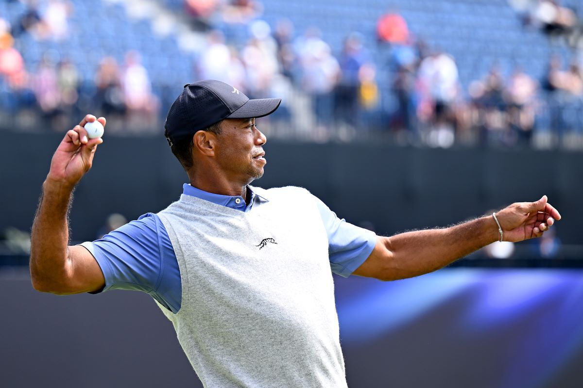 Tiger Woods throws his ball to a fan. (Image via Gettyimages)