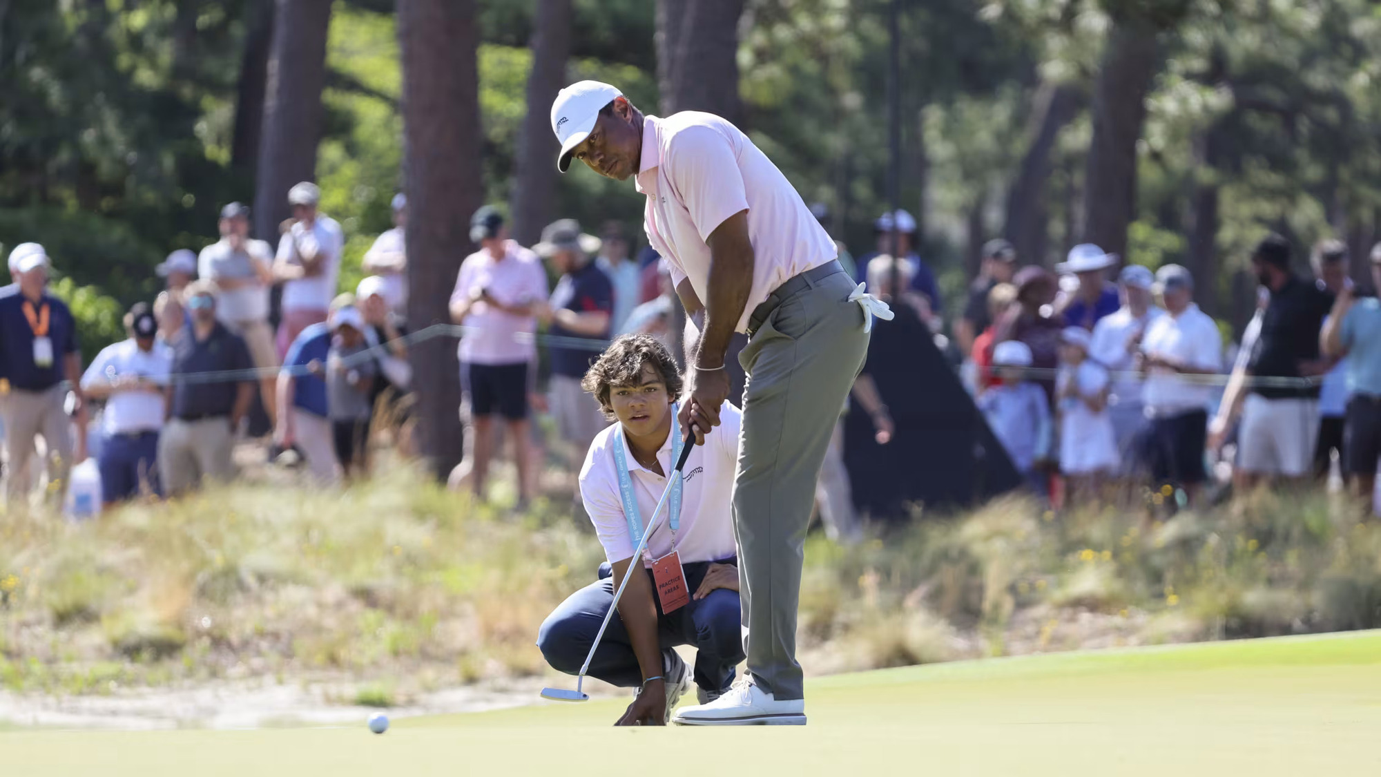 Tiger Woods gets in some putting work under the watchful eye of his son, Charlie, on Tuesday at Pinehurst No. 2  (Image via Gettyimages)