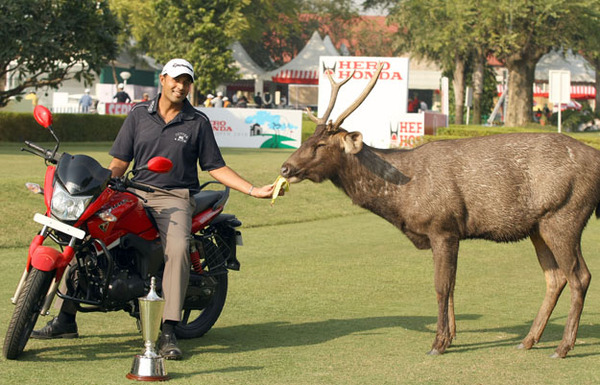 Arjun Atwal of India feeds the local Delhi Golf Club deer