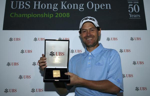 Simon Griffiths posing with the UBS gold bar, after a hole in One.