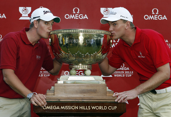 Henrik Stenson (L) and Robert Karlsson of Sweden kiss the Omega Mission Hills World Cup trophy after winning the event by three strokes.