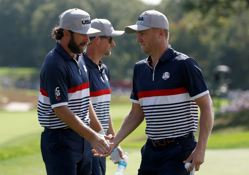 Justin Thomas of Team United States high-fives teammate Cameron Young
