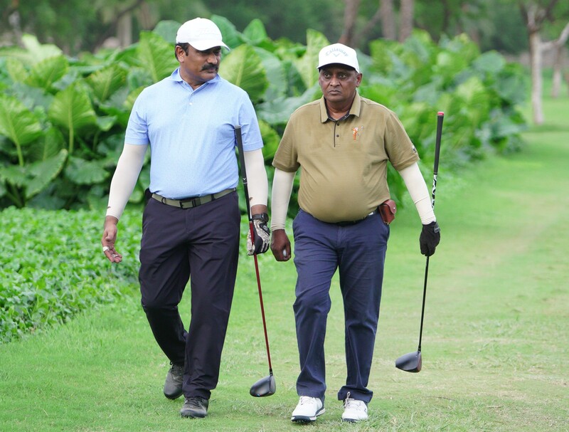 Two golfers walking side by side on a fairway